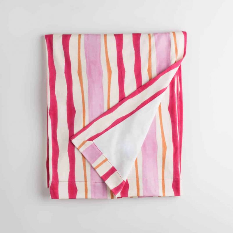 Luxury organic pink and orange mirrored watercolor stripe knit throw folded over