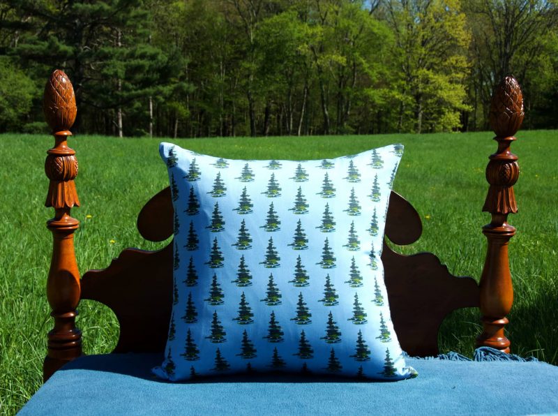 organic pine tree patterned pillow outside on a wooden poster bed