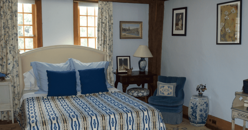 Light blue bedroom with watercolor stripe patterned organic coverlet
