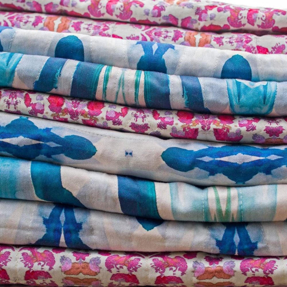 A stack of organic cotton sateen fabric by Linda Cabot Design