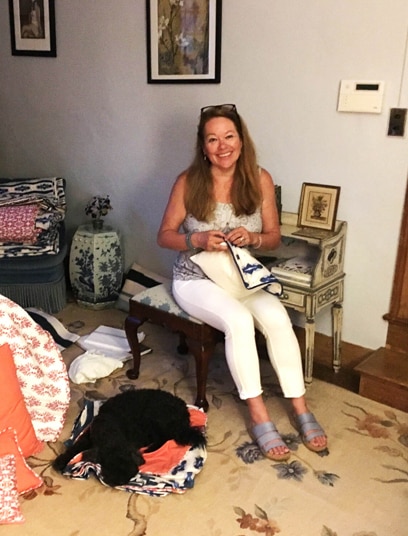 Linda Cabot sitting in a room with textile and her dog